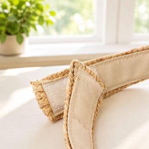 Close-up of the hook-and-loop velcro closure on the woven raffia straw visor headband