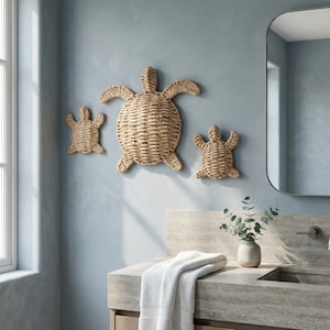 a bathroom with a sink, towel, and a decorative wicker turtle wall art piece.
