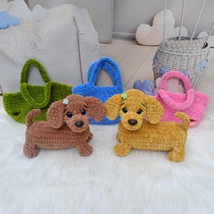 May include: A collection of handmade crochet dachshund dog toys and matching tote bags in various colors. The dogs are brown and yellow, with flower accents. The bags are green, blue, and pink, all with a soft, textured appearance.