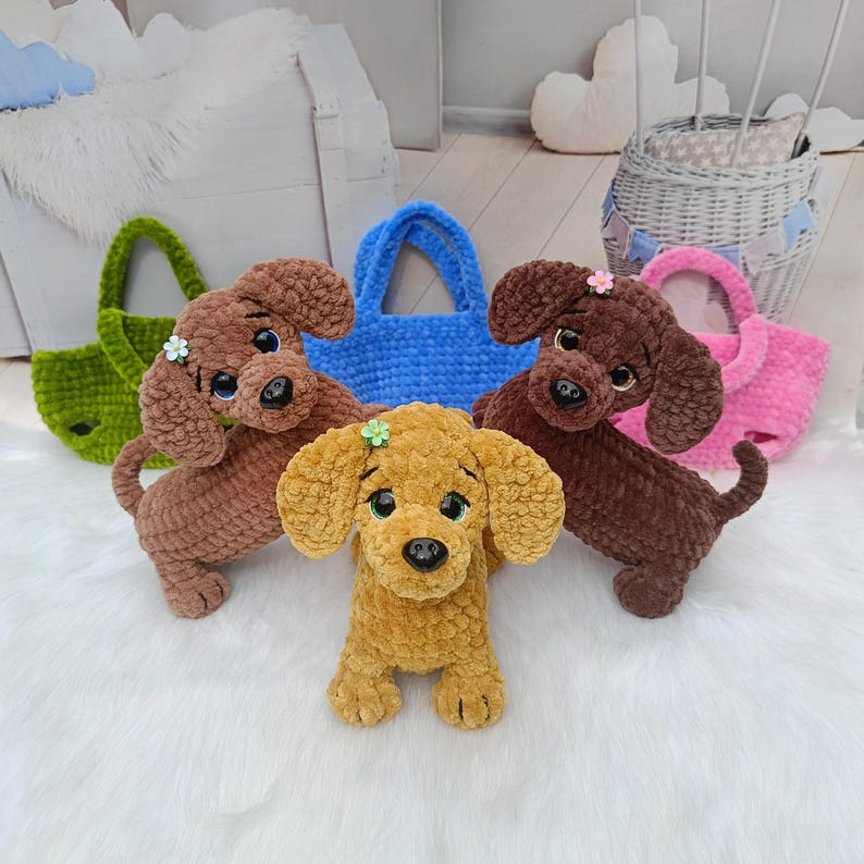May include: A collection of handmade crochet dog toys in various colors, including brown, yellow, and green. Each dog has large, expressive eyes and a small flower accessory. Several matching tote bags in blue and pink are also visible.
