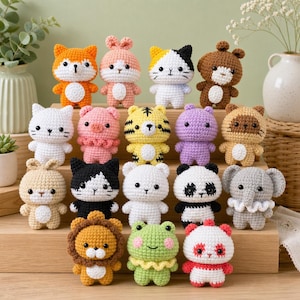 Op de afbeelding: Een verzameling handgemaakte gehaakte dierpoppen, waaronder een vos, kat, beer, varken, tijger, panda en olifant. Elke pop is felgekleurd en heeft gedetailleerde gezichtskenmerken. De poppen zijn gerangschikt op een houten oppervlak.