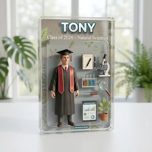 May include: A boxed action figure of a graduate in a black robe and red sash, labelled "TONY Class of 2024 - Natural Scientist." Accessories include a microscope, notepad, test tubes, and a tablet displaying scientific data. The figure is in a clear plastic case.
