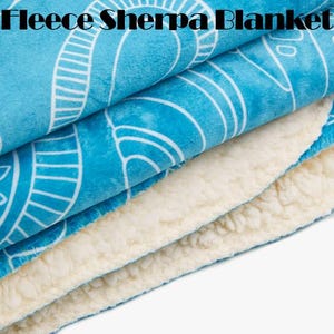 Puede incluir: Primer plano de una manta de forro polar Sherpa. La manta presenta una capa superior azul vibrante con un patr&oacute;n geom&eacute;trico blanco. La parte inferior es de material Sherpa suave de color crema. El texto "Fleece Sherpa Blanket" est&aacute; en la parte superior.