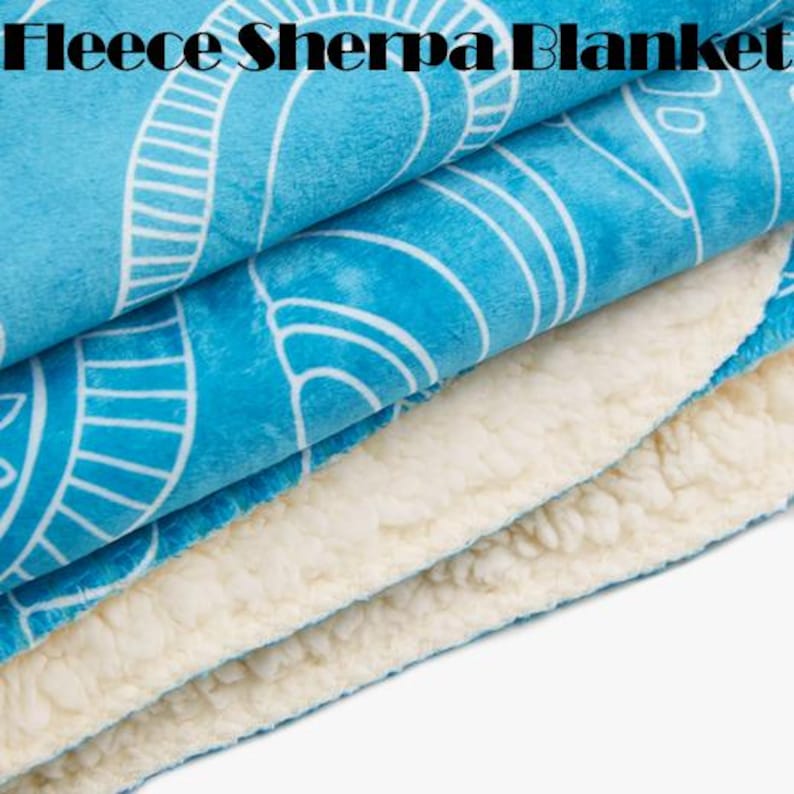 Puede incluir: Primer plano de una manta de forro polar Sherpa. La manta presenta una capa superior azul vibrante con un patr&oacute;n geom&eacute;trico blanco. La parte inferior es de material Sherpa suave de color crema. El texto "Fleece Sherpa Blanket" est&aacute; en la parte superior.