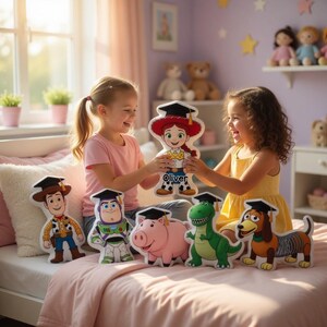 May include: A collection of plush character pillows from the Toy Story franchise, including Woody, Buzz Lightyear, Jessie, Rex, Hamm, and Slinky Dog, each wearing a graduation cap. The pillows are on a bed with two young girls.