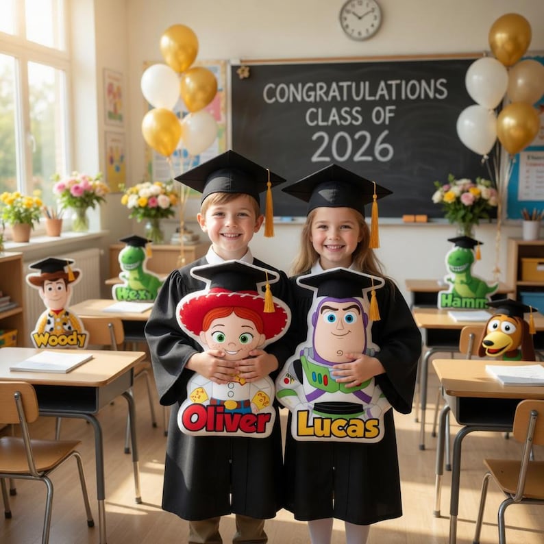 May include: Two children in graduation gowns holding character pillows, with the names "Oliver" and "Lucas" on them. The background includes a chalkboard that reads "CONGRATULATIONS CLASS OF 2026" and balloons.