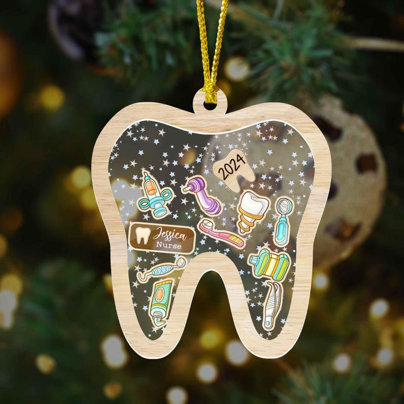 May include: Wooden Christmas ornament shaped like a tooth, featuring dental tools and the text "2024". The ornament includes the name "Jessica Nurse" on a small plaque. The background is filled with white stars.