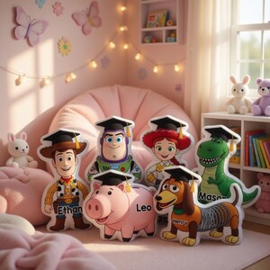 May include: A collection of plush character pillows, including Woody, Buzz Lightyear, Jessie, Rex, Slinky Dog, and Hamm, each wearing a graduation cap. The pillows are in a pink-themed room, with a beanbag chair and decorative butterflies.