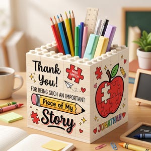 May include: A light-colored block-style pencil holder with the words "Thank You!" and "Piece of My Story" printed on it. The holder is filled with colorful pencils, pens, and a ruler. A red apple puzzle design is also featured. The name "Jonathan" is printed on the side.