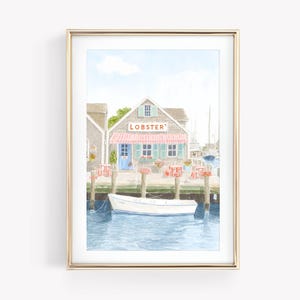 Puede incluir: Impresión en acuarela de una escena costera con un edificio con el letrero "Lobster" y un toldo a rayas rojas y blancas. Un pequeño bote blanco flota en el agua azul. La imagen está enmarcada en un marco dorado.