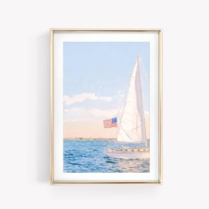 May include: Watercolor painting of a sailboat with a white sail and an American flag. The boat is on blue water, with a light blue sky and clouds in the background. The artwork is framed in a gold frame.