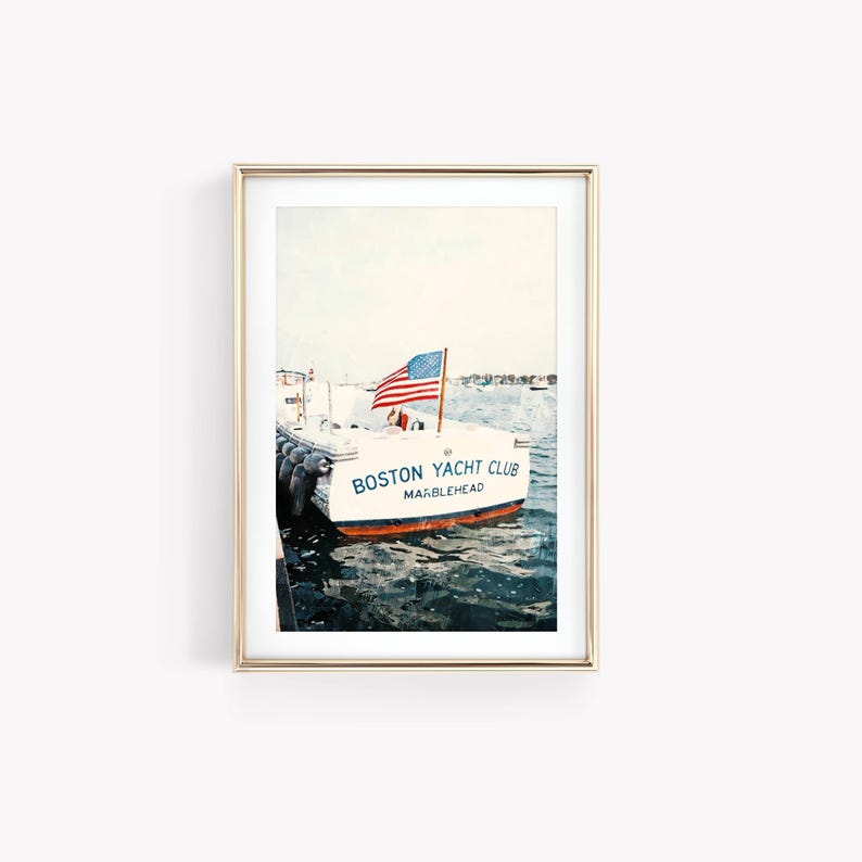 May include: A framed print featuring a white boat with the text "Boston Yacht Club Marblehead" in blue and red lettering. An American flag waves from the boat's mast. The boat is docked in the water, with black bumpers visible.