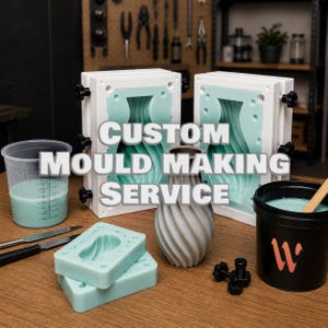 Può includere: Due telai rettangolari bianchi con inserti in silicone verde chiaro, un misurino trasparente con liquido verde chiaro, due blocchi in silicone verde chiaro, un vaso grigio a spirale e un secchio nero con bastoncino, etichettato CUSTOM MOULD MAKING SERVICE.