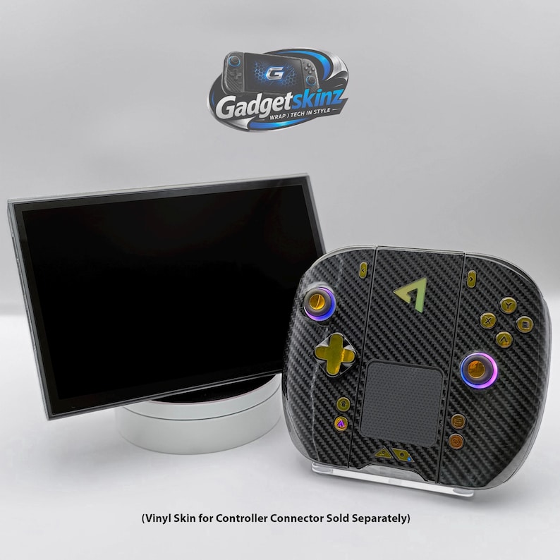 May include: A black carbon fibre textured vinyl skin applied to a handheld gaming controller with gold buttons and a black screen display. The Gadgetskinz logo is visible at the top. Text at the bottom reads: Vinyl Skin for Controller Connector Sold Separately.