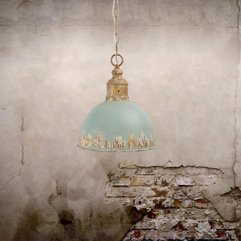 May include: A vintage-style pendant light with a distressed, light blue dome shade and a rusty gold-colored top. The light hangs from a chain, showcasing an industrial or farmhouse aesthetic. The shade has a weathered appearance, adding to its antique charm.