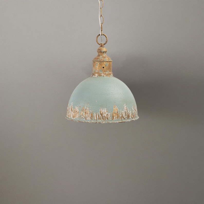 May include: A vintage-style pendant light with a distressed finish. The light fixture features a pale blue, dome-shaped shade with a weathered, off-white and gold trim. It hangs from a chain, offering a rustic, industrial aesthetic.