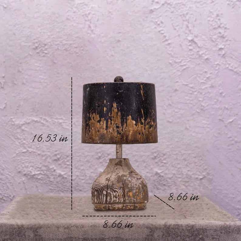 May include: A rustic table lamp with a black and gold painted lampshade and a wooden base. The lamp is 16.53 inches tall and the base is 8.66 inches wide.