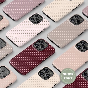 May include: A collection of phone cases in various colors, including burgundy, pink, and beige, each adorned with a polka dot pattern. The cases feature personalized initials and are designed for a smartphone. The image includes a sticker that says "SHIPS FAST".
