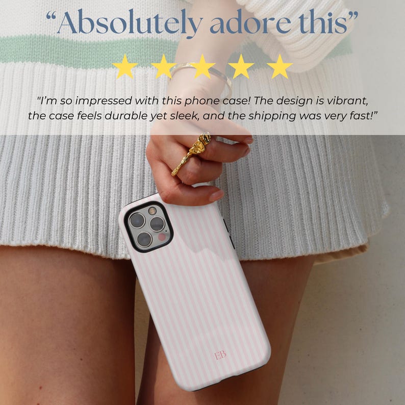 May include: A white phone case with pink stripes and a small "ER" logo. The case is being held by a person's hand. The text "Absolutely adore this" and five stars are visible above the case. The text "I'm so impressed with this phone case! The design is vibrant, the case feels durable yet sleek, and the shipping was very fast!" is visible below the case.