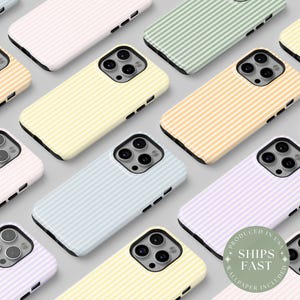May include: Assortment of colorful striped phone cases for iPhone 14 Pro. The cases feature a variety of pastel colors and thin white stripes. The cases are arranged in a grid pattern.