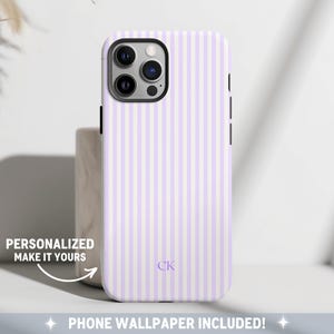May include: A white and light purple striped phone case with a black camera lens cutout and the initials "CK" in the center. The case is designed for an iPhone.