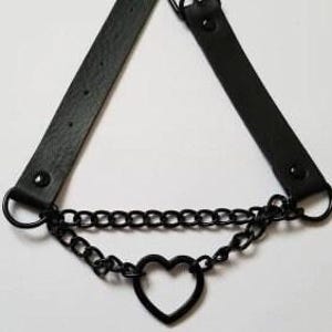 May include: Black leather choker necklace with a black metal chain and a heart-shaped pendant.