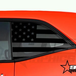May include: A red car with a black and white American flag decal on the rear window. The decal is on the passenger side window. The car is a Dodge Challenger. The decal is from 915 Graphics.