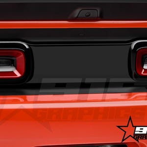 May include: A close-up of the rear end of a red Dodge Challenger with blacked-out taillights and a black rear bumper. The car has a black rear spoiler and a black rear diffuser. The car is sitting on a black surface. The image also includes the text "915 Graphics" in white letters on a black star.