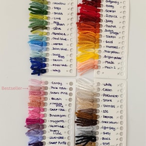 K&ouml;nnte beinhalten: Farbmuster von normalem Garn in verschiedenen Farbt&ouml;nen, darunter Gr&uuml;n, Blau, Rot, Orange, Rosa und neutrale T&ouml;ne. Jedes Muster ist mit einem Farbnamen und einer Nummer versehen. Der Text "Regular yarn" und "Bestseller" sind ebenfalls sichtbar.