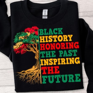 May include: Black sweatshirt with a colorful tree graphic and the text "Black History Honoring The Past Inspiring The Future" in green, yellow, and red. The tree has red, green, and yellow leaves.