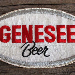 May include: White oval patch with red embroidered text "GENESEE" and black embroidered text "Beer".