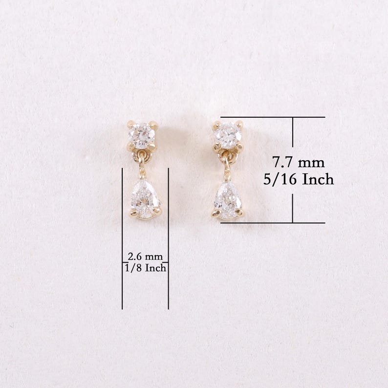 May include: A pair of gold-toned earrings with a small, square-shaped top and a pear-shaped drop. The earrings are 5/16 inch (7.7 mm) long and 1/8 inch (2.6 mm) wide. The earrings are set against a white background.