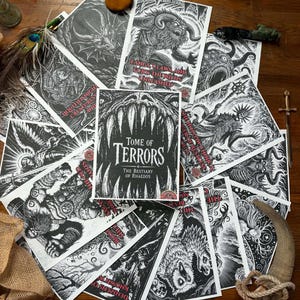 以下が含まれることがあります： 様々なモンスターやクリーチャーを描いた白黒のファンタジーアートプリントのコレクション。中央のプリントには「Tome of Terrors The Bestiary of Rhaedos」という文字と鋭い歯が描かれています。他のプリントには、角のある獣、戦士、闇の存在などが描かれています。