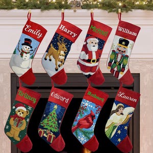 May include: Eight personalized Christmas stockings with red cuffs and toes. Each stocking features a unique holiday design including a snowman, reindeer, Santa Claus, nutcracker, teddy bear, Christmas tree, cardinal bird, and an angel.