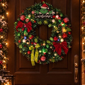 Peut inclure: Une couronne de Noël en guirlande verte avec une découpe du personnage Grinch portant l'inscription "welcome" et "Merry Grinch Mas". La couronne est ornée de nœuds rouges, de boules rouges et vertes, de pompons blancs et de lumières LED.