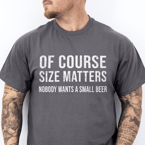 May include: A dark gray t-shirt with the text "Of course size matters. Nobody wants a small beer." printed in white.