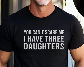 Może przedstawiać: Czarny t-shirt z nadrukiem "You can't scare me I have three daughters" w kolorze białym.