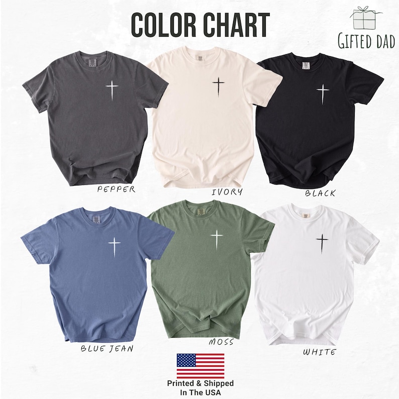 May include: A color chart displays six short-sleeved t-shirts in various colors: pepper, ivory, black, blue jean, moss, and white. Each shirt features a white cross graphic on the front. The text "COLOR CHART" is at the top.