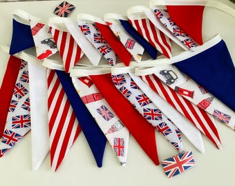 May include: A bunting with red, white, and blue triangular flags. The flags feature a variety of designs, including the Union Jack, stripes, and a small car. The bunting is perfect for a patriotic celebration.