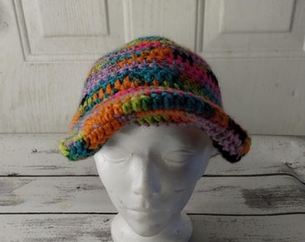 May include: A colorful crocheted bucket hat with a wide brim. The hat is made with a variety of colors, including orange, pink, green, blue, and black.