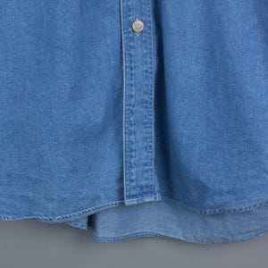 以下が含まれることがあります： 長袖とボタンダウンフロントが付いた、明るい青色のデニムシャツ。 シャツは、カーブした裾と襟に1つのボタンが特徴です。 デニム生地は少し色あせた外観をしています。 クラシックなスタイルです。