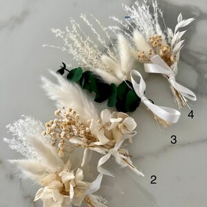 May include: Four bouquets of dried flowers with white ribbon. The bouquets are arranged in a row from left to right, numbered 1 through 4. Each bouquet includes white pampas grass, white hydrangeas, and small white flowers.