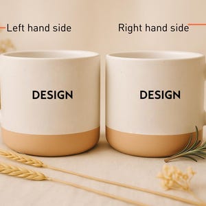 May include: Two white ceramic mugs with a tan base and handle, each displaying the word "DESIGN" in black. The mugs are set on a neutral surface, accompanied by wheat stalks and greenery.