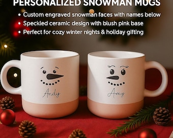 May include: Two white ceramic mugs with snowman faces, personalized with names. The mugs have a speckled design and a blush pink base. The text "PERSONALIZED SNOWMAN MUGS" is at the top.