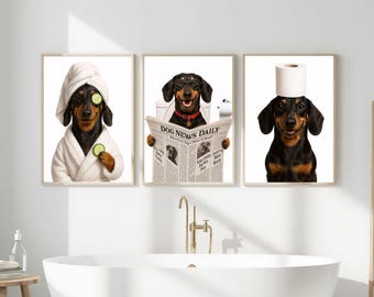 May include: Set of three framed prints featuring dachshunds in humorous bathroom scenes. One dog wears a spa towel and cucumber slices, another reads a newspaper, and the third has a toilet paper roll on its head.