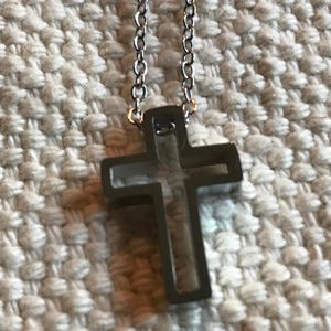 May include: A silver chain necklace with a hollow, open cross pendant.