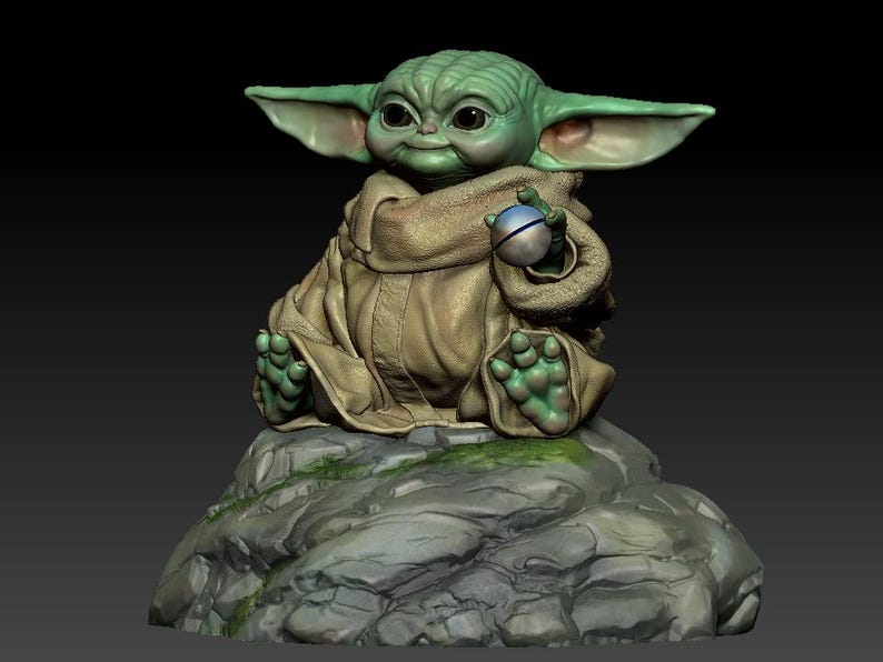 May include: A green and brown figurine of a character from the Star Wars franchise, sitting on a rock with a small sphere in its hand.