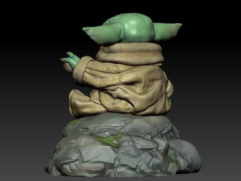 May include: A green and brown figurine of a character from the Star Wars franchise sitting on a rock. The character is wearing a brown jacket and has large ears.