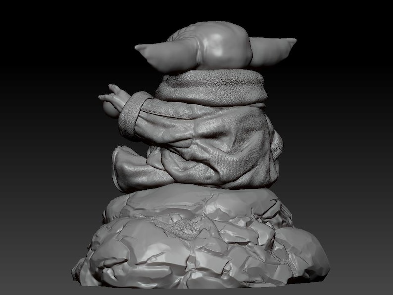 May include: A gray 3D printed figurine of a character from the Star Wars franchise, sitting on a rocky base. The character is wearing a hooded jacket and has large ears.