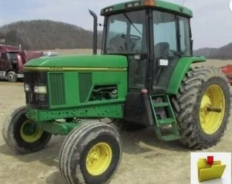 May include: A green John Deere tractor with a cab, large tires, and yellow rims. The tractor has the model number 7200 on the side. The tractor is parked on a dirt surface.